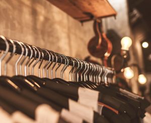 Retail business 121 coaching training photo of lightbulbs above clothes on black hangers